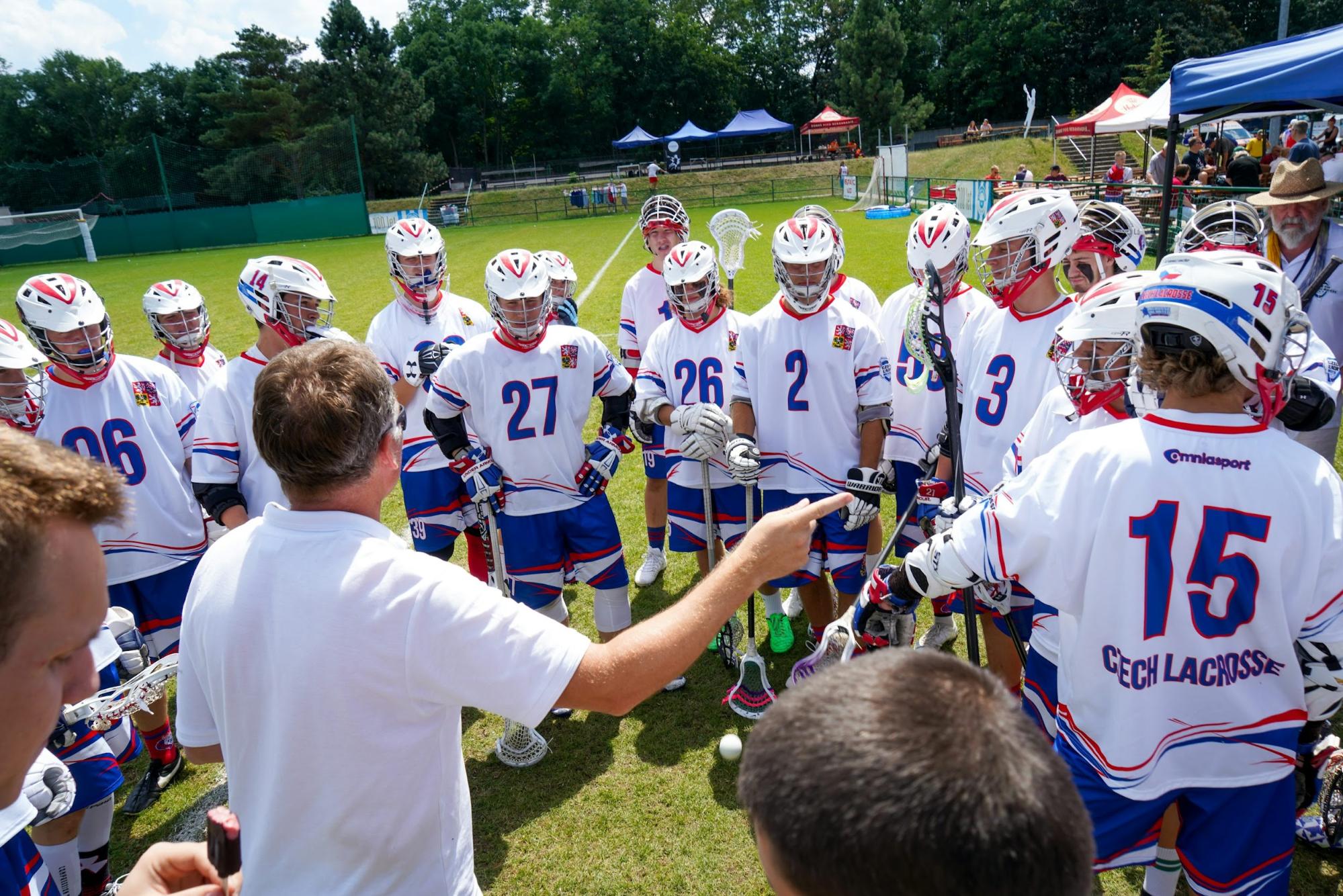 huddle of lacrosse players on the field