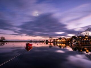 A waterfront in Fairfield, CT, visible from the water at dusk.